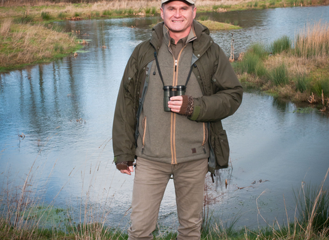 Simon King standing in front of a pond